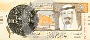 100 saudi riyal coin against 10 saudi riyal bank note