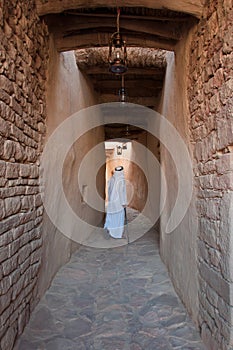 Saudian walking inside the walls of Al-Ula Old City, Saudi Arabia