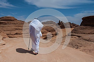 Saudian walking on top of rock formations, Saudi Arabia photo