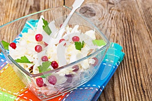 Sauerkraut with cranberries in a glass bowl on a wooden backgro