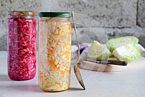 Sauerkraut in glass jar, marinated cabbage, carrot and beetroot. Probiotic and fermented food. Pickles. Canned vegetarian food con photo