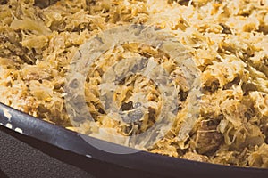 Sauerkraut with mushrooms on frying pan. Caloric food