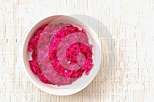 Sauerkraut and red beet in the bawl on the white background