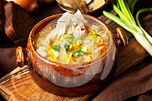 Sauerkraut soup in ceramic bowl on wooden table