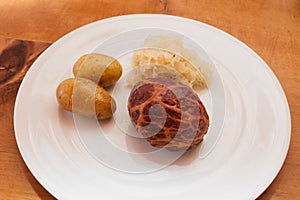 Saumaise, a pork caul filled with meat, with Sauerkraut and Potatos