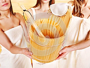 Sauna bucket holding by group woman.
