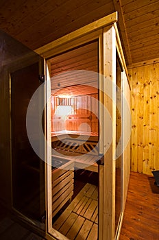 Sauna interior cabin detail with open door and lit lighting