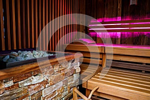 Sauna Interior with Stone Heater, Wooden Benches and Ambient Lighting