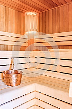 Sauna room. Wooden sauna interior with copper bucket.