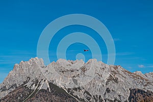 Sauris - Small airplane flying over the majestic mountain ridges of Carnic Alps near Sauris di Sopra