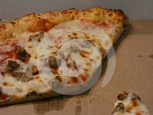 sausage and cheese pizza on cardboard delivery box photo