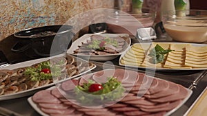 Sausage and cheese slicing are on plates at Breakfast buffet, morning in hotel