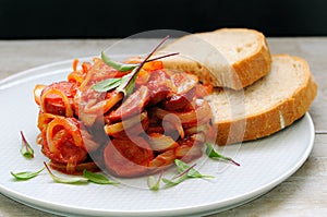 Sausage fried with onion and ketchup sauce. photo