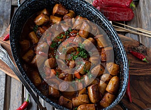 Sausage goulash, spicy hungarian style in a rustic pot