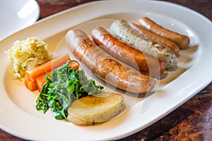 Sausage grill with vegetable on white dish