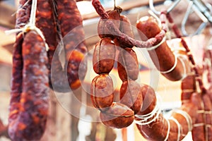 The sausage is hanging on the counter in the store. Trade in meat delicacies. Close-up