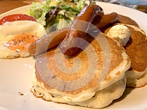 Sausage on a pancake. Breakfast meal with lettuce salad.