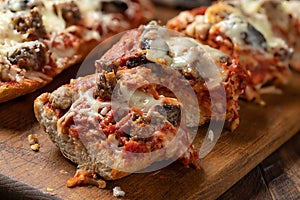 Sausage pizza bread on cutting board