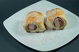 Sausage roll in the dough on a white plate