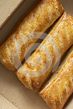 Sausage rolls in a cardboard takeaway tray. Sustainable biodegradable recycling packaging concept