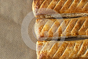 Sausage rolls cooked on brown greaseproof baking paper. Traditional British food