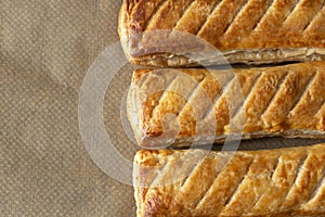 Sausage rolls cooked on brown greaseproof baking paper. Traditional British food photo