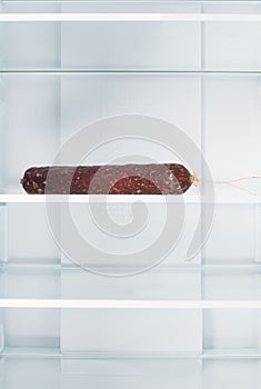 Sausage on a shelf in an empty refrigerator