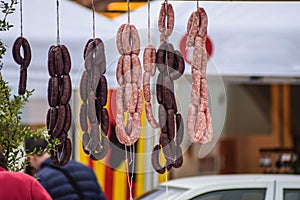 Sausages and black pudding hanging on a market photo