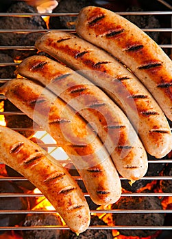 Sausages cooking on a barbecue fire