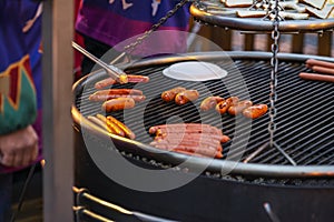 Sausages Cooking outside on open fire. Christmas street markets, fair. Winter holidays and weekends