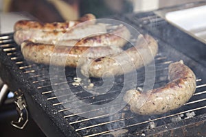 Sausages cooking over the hot coals on a barbecue fire