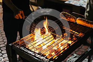 Sausages grill with burning charcoal with fire on the stove with grill on top in Bangkok, Thailand