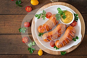 Sausages on the grill with vegetables. Top view