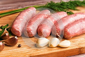 Sausages for grilling, dill and garlic on a wooden cutting board