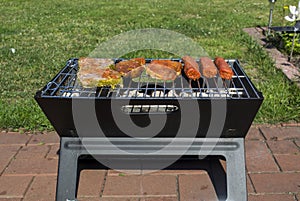 The sausages and meat on grill. Summer picnic outdoor.