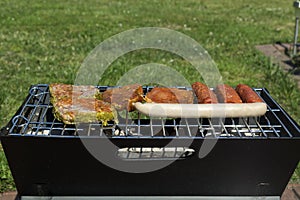 The sausages and meat on grill. Summer picnic outdoor.