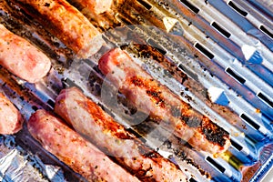 Sausages meat grilling on gas grill
