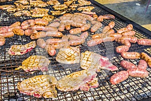 Sausages and pork steaks on the large barbeque