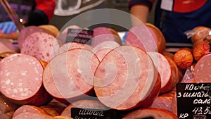 Sausages with Price Tags on the Showcase in the Store. Sellers Stand behind the Counter in the Supermarket