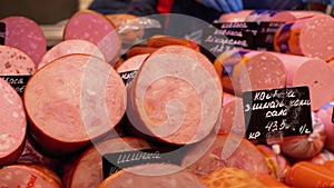 Sausages with Price Tags on the Showcase in the Store. Sellers Stand behind the Counter in the Supermarket