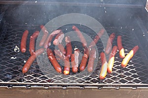 Sausages roasting on the grill.