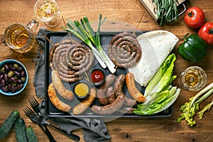 Sausages served with tomato sauce, mustard and beer for pub  an outdoor party, top down view