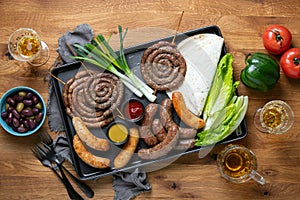 Sausages served with tomato sauce, mustard and beer for pub  an outdoor party, top down view