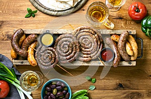 Sausages served with tomato sauce, mustard and beer for pub  an outdoor party, top down view