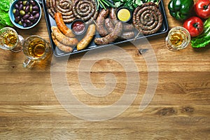 Sausages served with tomato sauce, mustard and  beer, summer outdoor party culinary idea, top down view