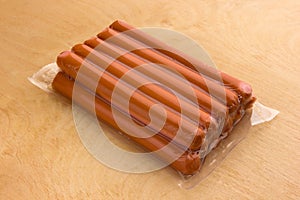 Sausages vacuum packed on a wooden surface.