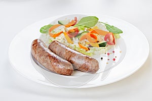 Sausages with vegetables on a white background beautifully elegantly refined restaurant