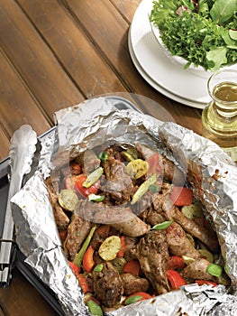 Sausages and wings in papillote with vegetables