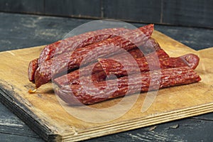 Sausages on a wooden kitchen board close up, cooking meat snacks