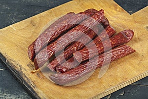 Sausages on a wooden kitchen board close up, cooking meat snacks